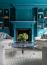 45 - Sissy Yellen, Bold library design featuring teal built-in bookshelves, a decorative fireplace mantel, a modern glass coffee table, symmetrical armchairs, and a geometric patterned area rug, creating an elegant and vibrant statement interior.