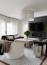 52 - Sissy Yellen, Modern living room design featuring a neutral and black color palette, plush upholstered furniture, a sleek black fireplace, a large modern drum pendant light, a textured area rug, and a contemporary coffee table with bright natural light streaming in.