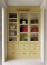 57 - Sissy Yellen, Elegant custom closet featuring a yellow built-in cabinet with glass-front doors showcasing a curated collection of designer handbags in various colors and styles. The lower drawers provide additional storage, while the neutral carpet adds sophistication to the space.